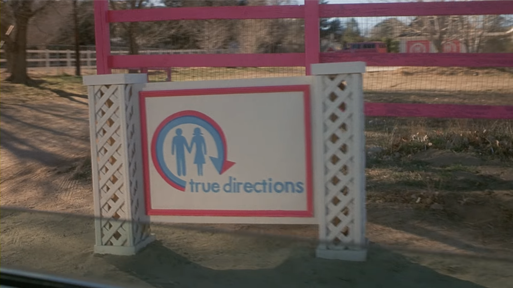 the sign in front of the true directions building, with the logo of 2 silouhettes representing men and women inside a pink and blue arrow in the shape of a circle