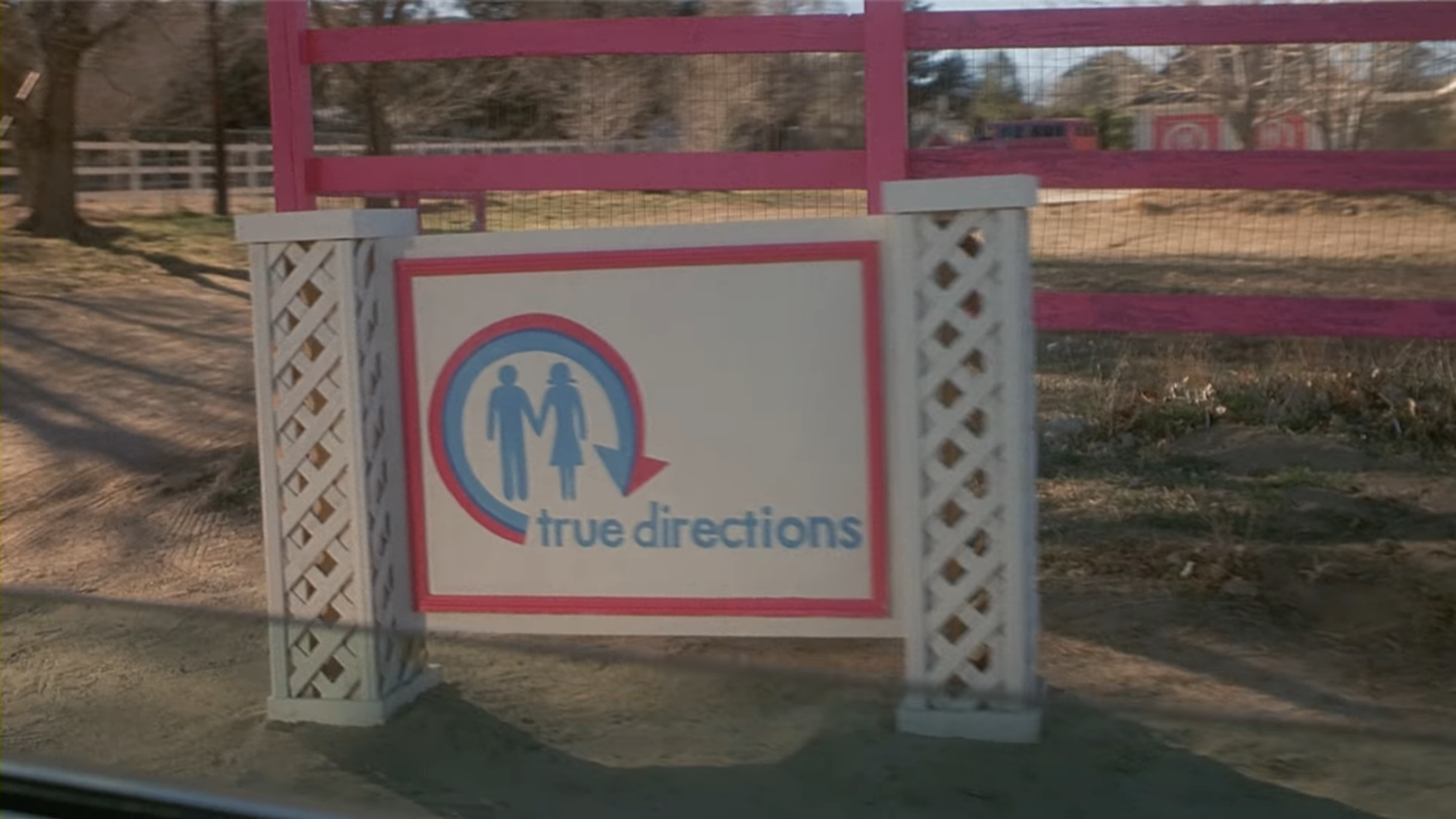 the sign in front of the true directions building, with the logo: 2 silouhettes representing men and women inside a pink and blue arrow, pointing in the shape of a circle